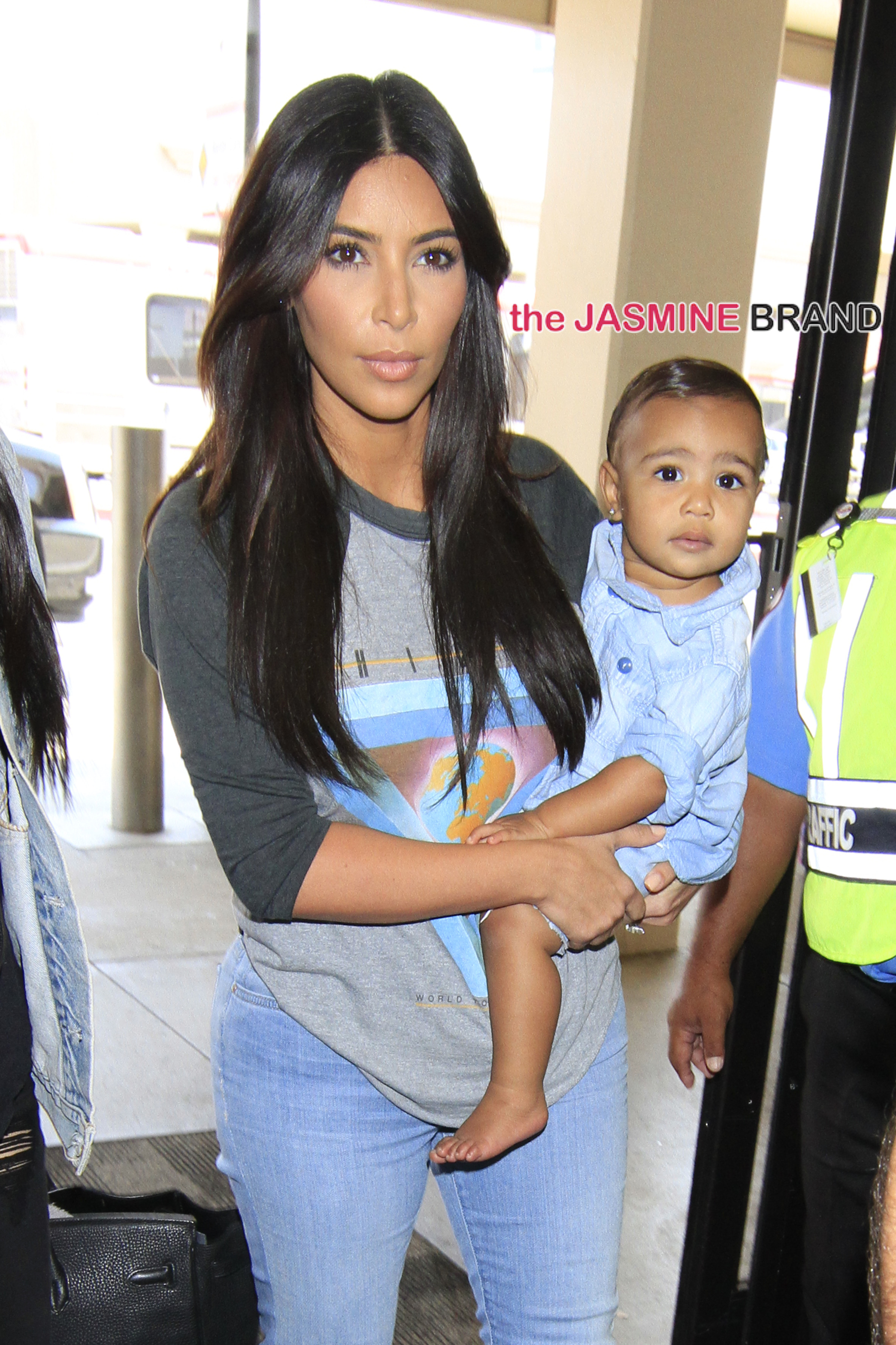 Kim Kardashian kisses her cute 14-month-old daughter, North West as they make their way through Burbank Airport.  The "Keeping up with the Kardashians" star was seen wearing heels and tight jeans showing off her famous butt.